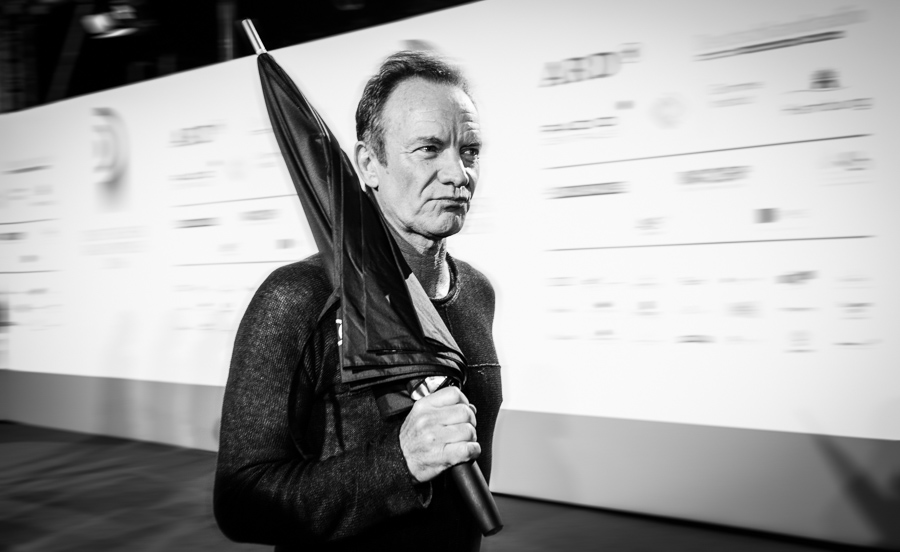 Sting auf dem roten Teppich in Hamburg mit einem Regenschirm